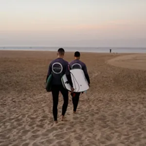 Photo de deux surfers sur la plage